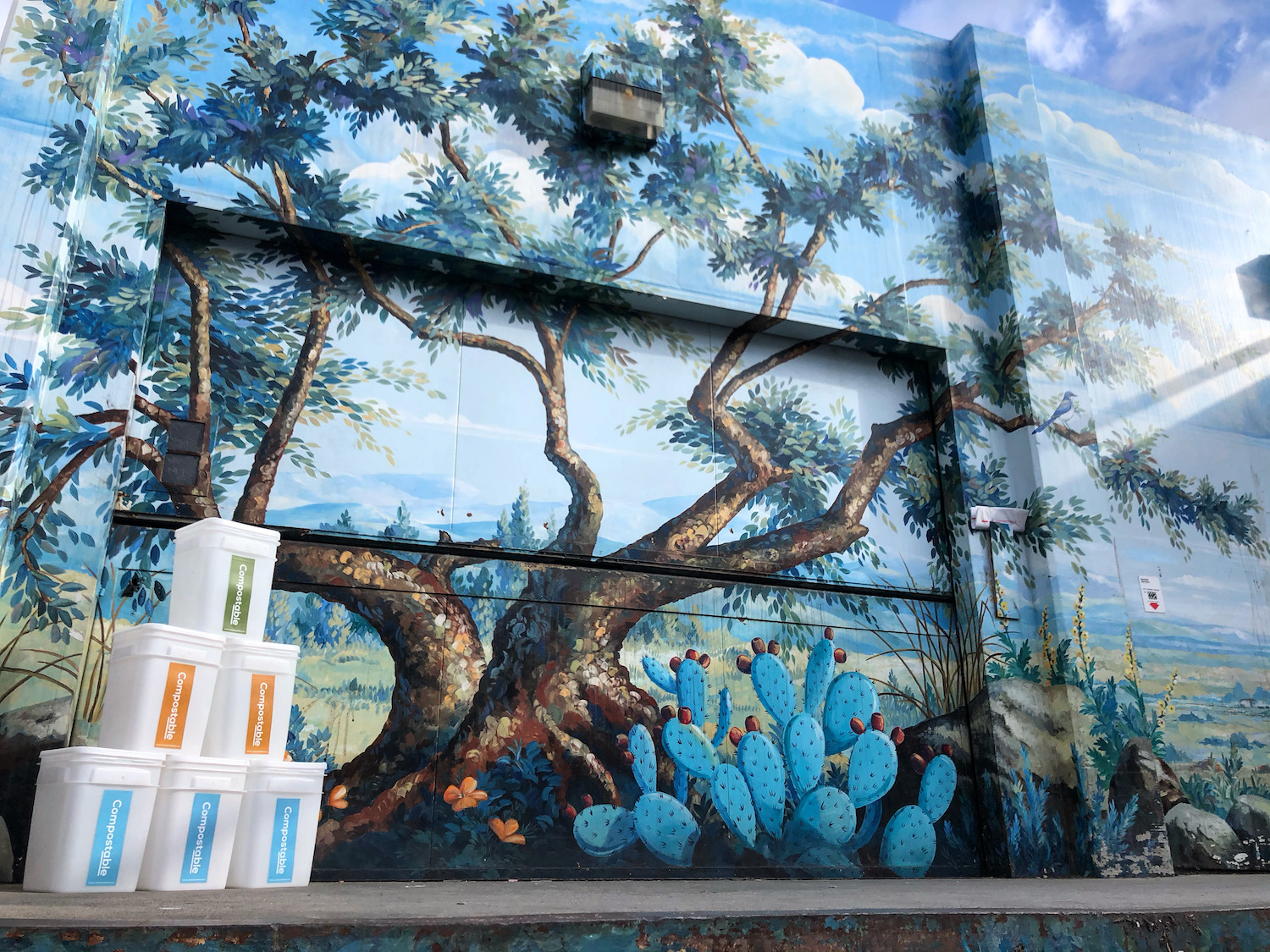 Compostable Bins stacked in front of wall art